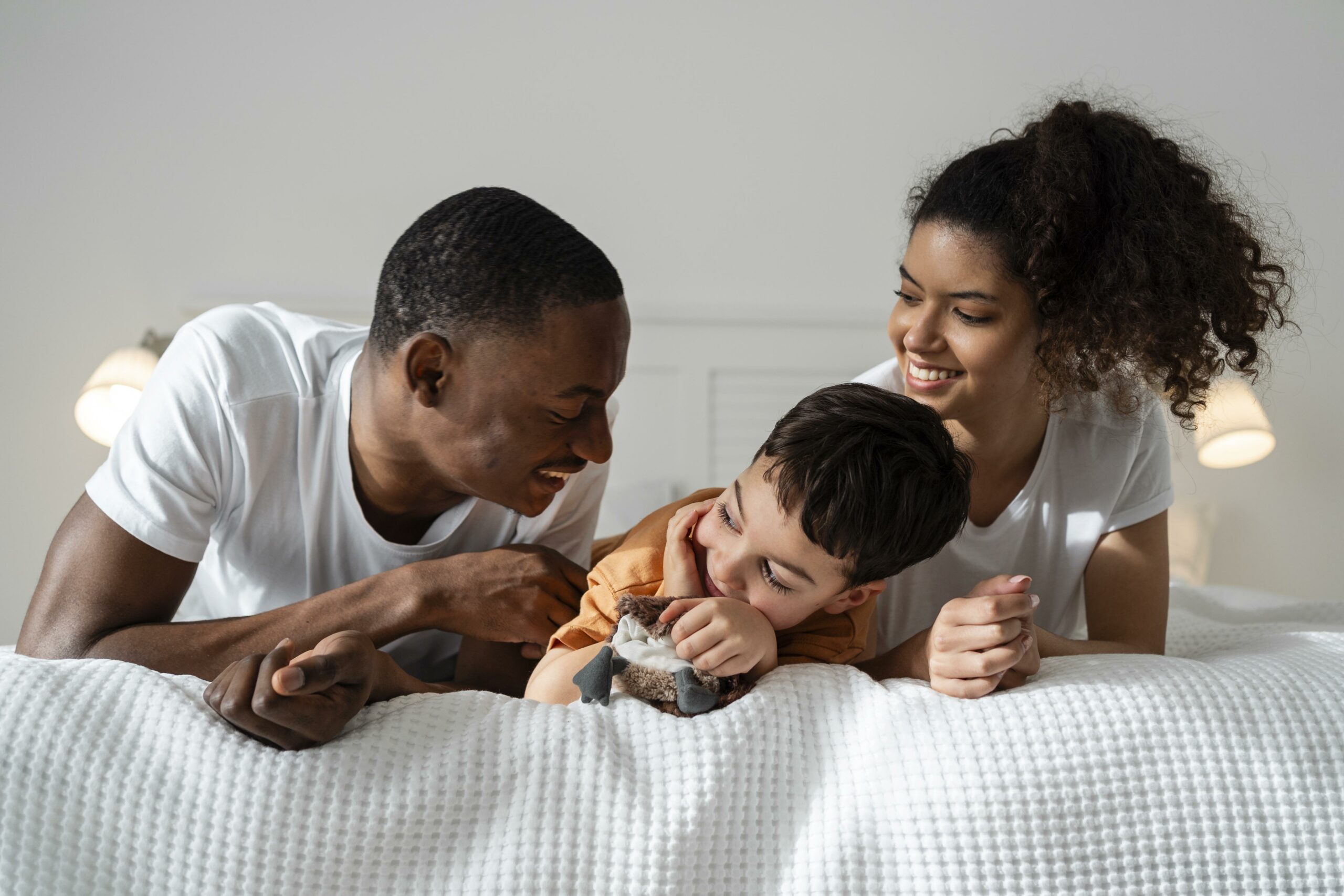 familia negra alegre deitados na cama